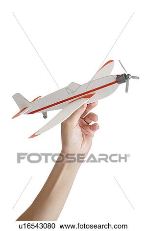 Stock Image - Human hand holding a model airplane. Fotosearch
