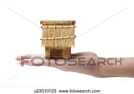 Stock Image - Human hand holding a model house. Fotosearch