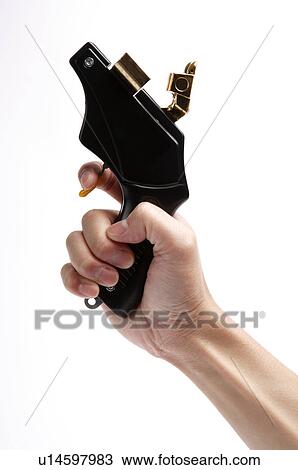 Stock Image - Human hand holding a starting gun. Fotosearch