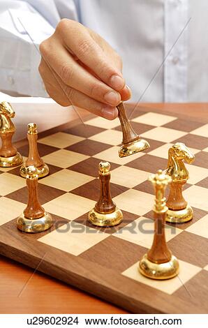 Picture - Human hand playing chess. Fotosearch