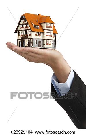 Picture - Human hand showing a model house. Fotosearch