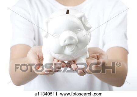 Stock Image - Human hands holding a piggy bank. Fotosearch