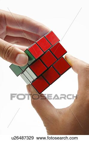 Stock Photo - Human hands playing a puzzle cube. Fotosearch