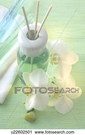 Stock Image - Aroma lamp with aroma sticks and orchid blossoms. Fotosearch