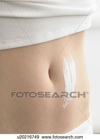 Stock Photo - Cream streaks on a belly. Fotosearch
