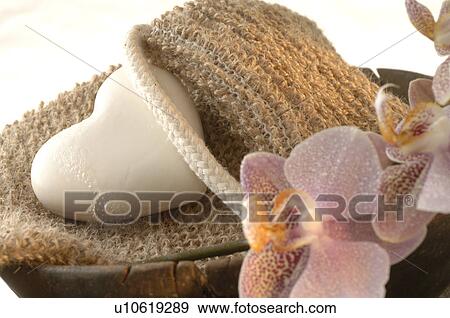 Stock Photo - massage belt and heart-shaped soap decorated with flowers in a wooden bowl. Fotosearch