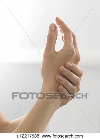 Stock Photo - Woman is putting lotion onto her hands. Fotosearch