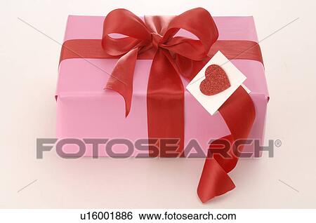 Gift with a red ribbon and a red heart View Large Photo Image Stock Photograph - Gift with a red ribbon and a red heart. Fotosearch