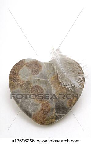 Stock Photograph - Heartshape stone and a white feather. Fotosearch