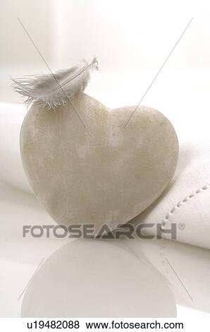 Stock Photo - White stone and a white feather. Fotosearch