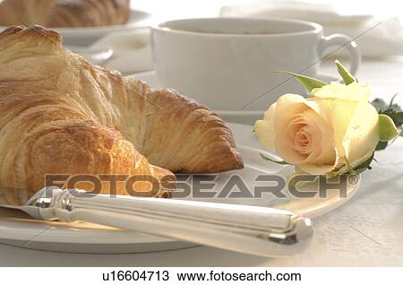 Place setting with a croissant and a white rose blossom View Large Photo Image Stock Image - Place setting with a croissant and a white rose blossom. Fotosearch