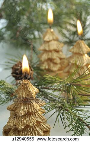 Stock Photography - Golden Christmas tree shape candles. Fotosearch