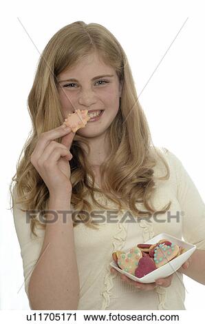 Stock Image - Woman eating Christmas biscuits. Fotosearch