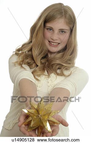 Woman holding a golden Christmas star View Large Photo Image Stock Photo - Woman holding a golden Christmas star. Fotosearch