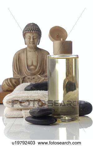 Stock Image - Small buddha and massage oil. Fotosearch