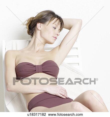 Woman in bikini lying on deck chair View Large Photo Image Stock Image - Woman in bikini lying on deck chair. Fotosearch