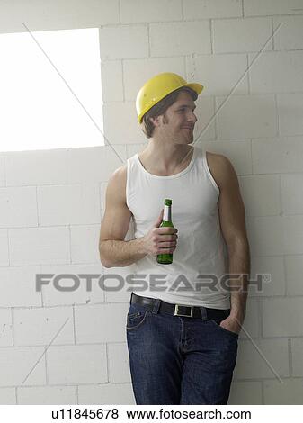 Stock Photo - Construction worker holding a bottle of beer. Fotosearch