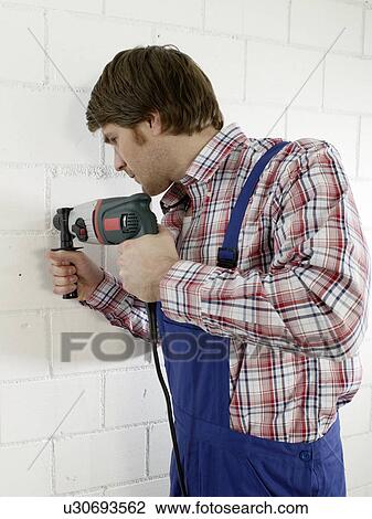 Man is using a driller View Large Photo Image Stock Image - Man is using a driller. Fotosearch