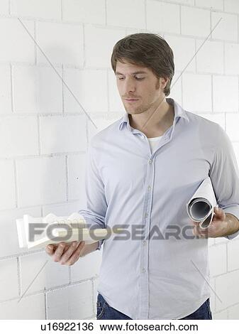Stock Photograph - Mann holding a small model house. Fotosearch