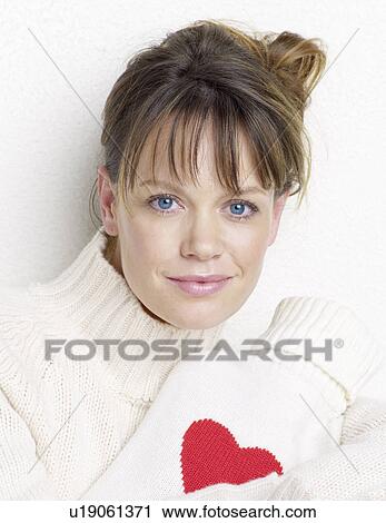 Stock Image - young woman with hot water bottle heart-style. Fotosearch
