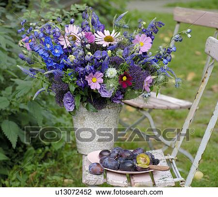 Stock Image - Spray of flowers on a garden chair. Fotosearch