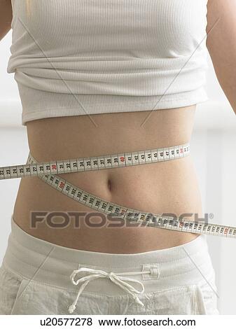 Stock Photo - Belly wrapped by a measuring-tape. Fotosearch