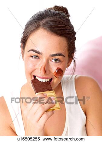 Brunette woman eating chocolate View Large Photo Image Stock Photography - Brunette woman eating chocolate. Fotosearch