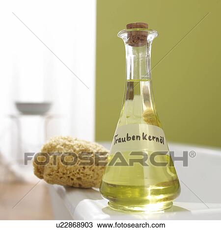 Stock Image - Grapeseed oil and natural sponge at the margin of bath. Fotosearch