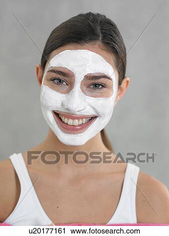 Stock Image - Laughing woman with curd mask. Fotosearch