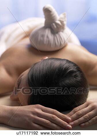 Woman with compress on a massage table View Large Photo Image Stock Image - Woman with compress on a massage table. Fotosearch