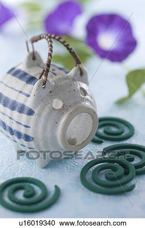 Stock Image - Mosquito Coil and Pig-shaped Container. Fotosearch