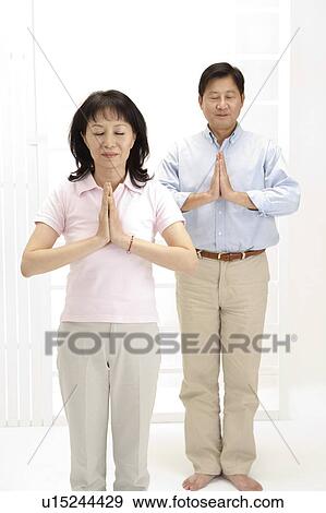 Couple, Couple standing with hands praying and eyes closed View Large Photo Image Stock Photo - Couple, Couple standing with hands praying and eyes closed. Fotosearch