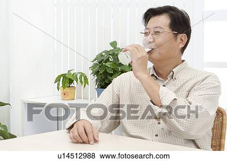 Stock Photo - Husband, Man holding a glass and drinking. Fotosearch
