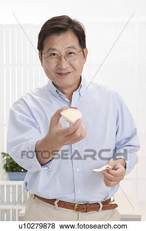 Husband, Man holding food and smiling at the camera View Large Photo Image Stock Photo - Husband, Man holding food and smiling at the camera. Fotosearch
