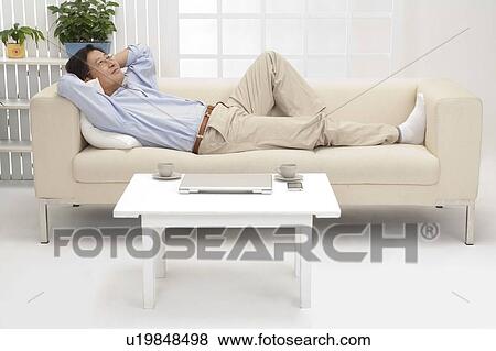 Husband, Man lying on sofa and looking up with smile View Large Photo Image Stock Photo - Husband, Man lying on sofa and looking up with smile. Fotosearch