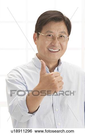 Stock Photograph - Husband, Man smiling at the camera with thumbs up. Fotosearch