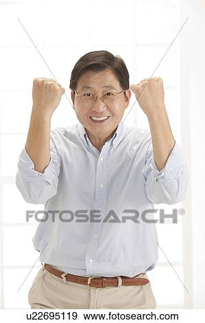 Stock Photo - Husband, Man standing with fists up and smiling with confidence. Fotosearch