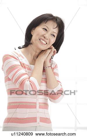 Wife, Woman holding hands with head cocked and smiling View Large Photo Image Stock Photo - Wife, Woman holding hands with head cocked and smiling. Fotosearch