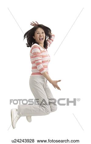 Stock Photo - Wife, Woman jumping in mid-air and laughing. Fotosearch