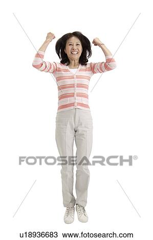Stock Image - Wife, Woman jumping with arms raised and laughing. Fotosearch