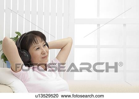 Wife, Woman lying on sofa and listening music with smile View Large Photo Image Stock Image - Wife, Woman lying on sofa and listening music with smile. Fotosearch
