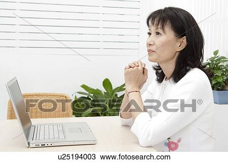 Woman holding hands and looking away View Large Photo Image Stock Image - Woman holding hands and looking away. Fotosearch