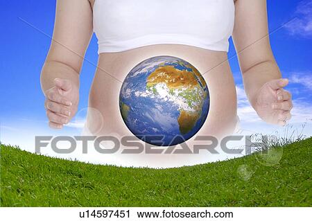 Stock Image - Lohas, Environmental Conservation, Digitally generated image of a pregnant woman with image of earth and grass before her. Fotosearch