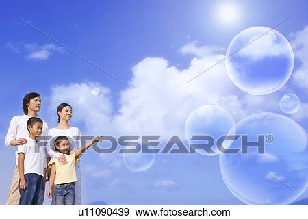 Lohas, Environmental Conservation, Digitally generated image of a family of four people looking away in blue sky View Large Photo Image Stock Photo - Lohas, Environmental Conservation, Digitally generated image of a family of four people looking away in blue sky. Fotosearch