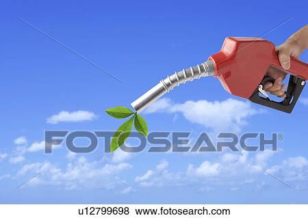 Stock Photo - Lohas, Environmental Conservation, Digitally generated image of human hand holding a fuel pump with a green leaf on the outlet. Fotosearch