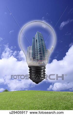 Stock Photo - Lohas, Environmental Conservation, Digitally generated image of light blub with building in the blue sky and grass. Fotosearch