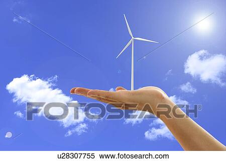 Stock Photography - Lohas, Environmental Conservation, Digitally generated image of human hand holding a windmill in blue sky. Fotosearch