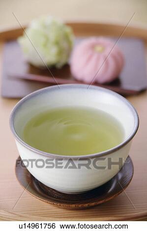 Stock Photograph - A cup of green tea and sweets. Fotosearch