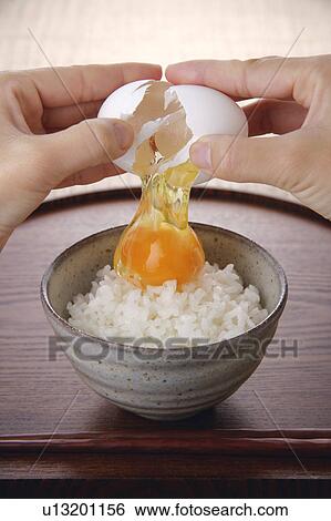 A woman cracking an egg above steamed rice View Large Photo Image Stock Photograph - A woman cracking an egg above steamed rice. Fotosearch