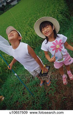 Boy and girl standing in rice paddy View Large Photo Image Stock Photo - Boy and girl standing in rice paddy. Fotosearch